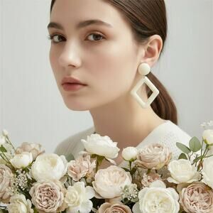 Clip on 2 1/2" gold and cream plastic dangle cutout earrings